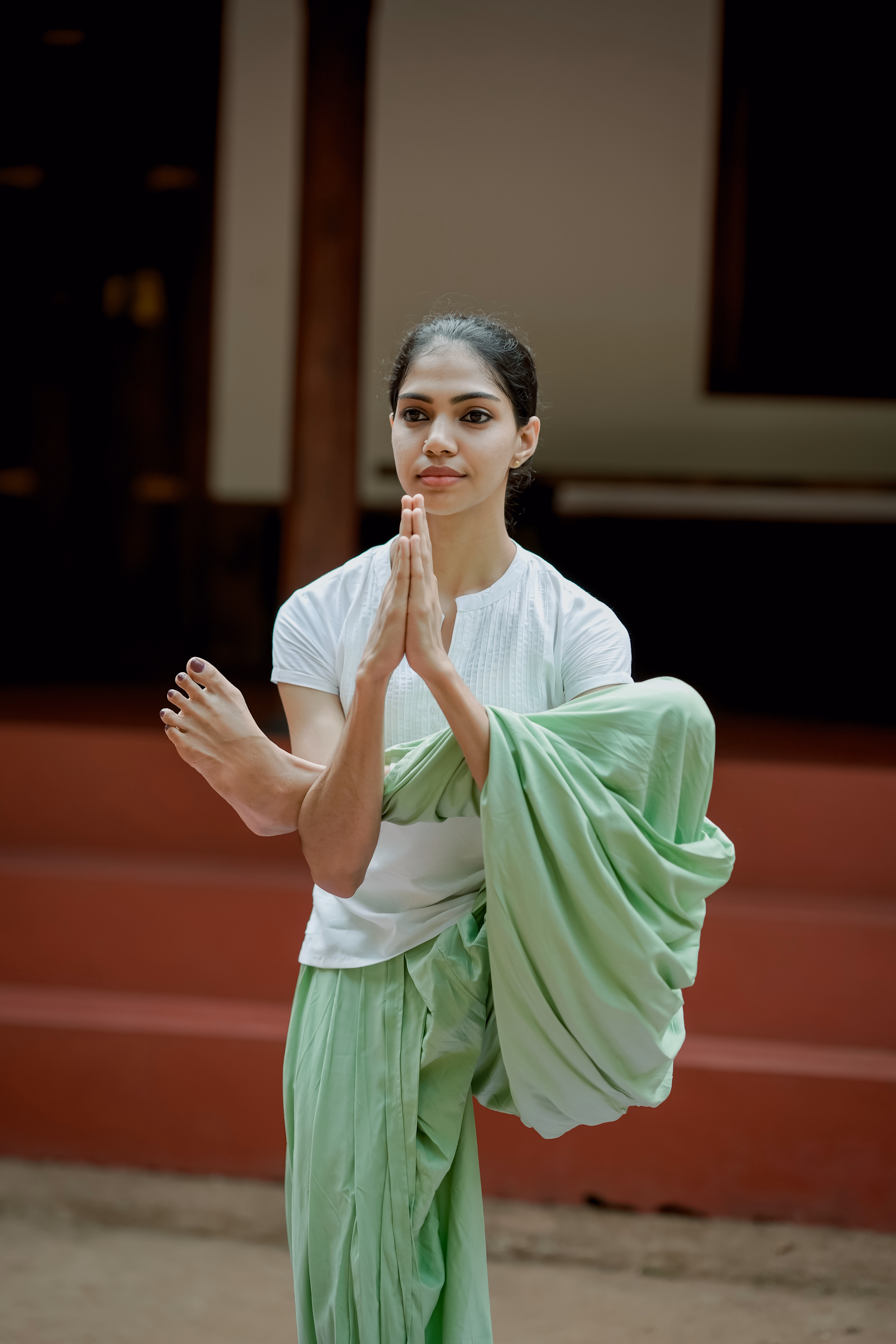 Person practicing yoga with hands in prayer position above head
